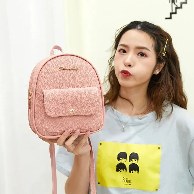 Women's compact black PU bag worn as both a shoulder bag and a small backpack.