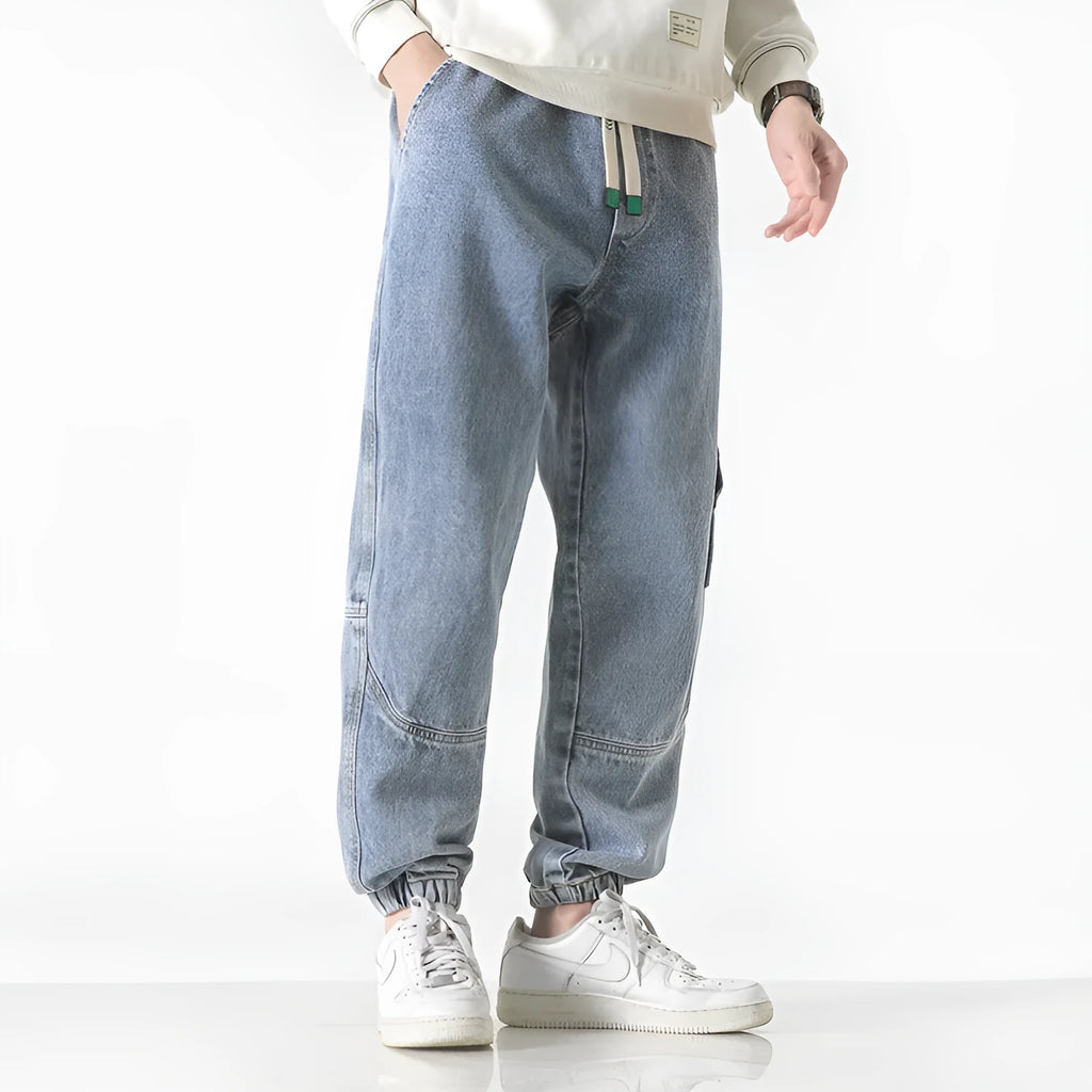 Men's loose-fit tapered cotton trousers in black showing tapered leg and mid-waist design