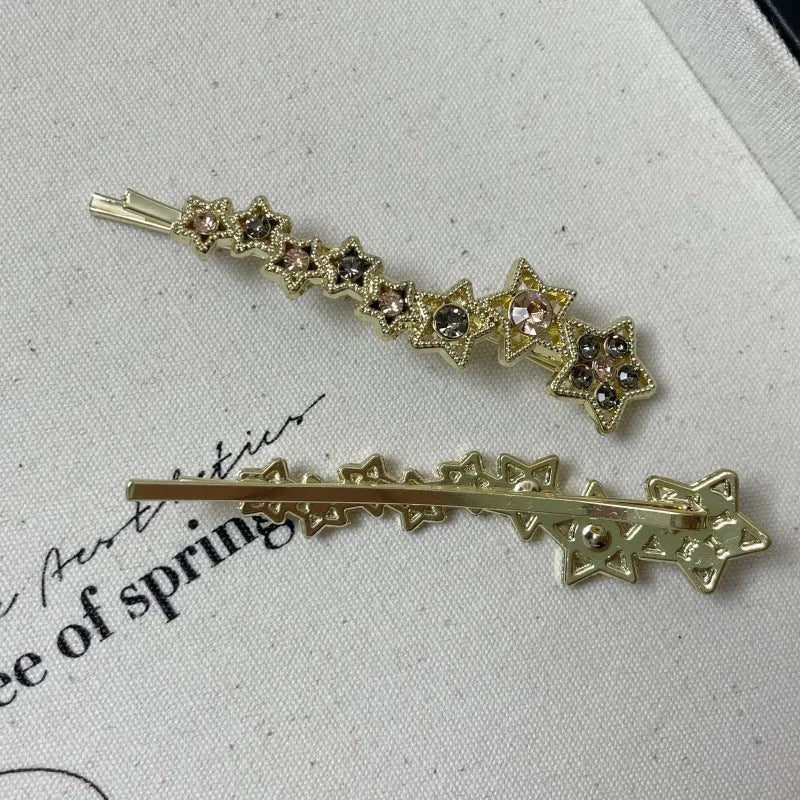 Gold-coloured alloy hair barrette with five-pointed star decoration and side-clip mechanism