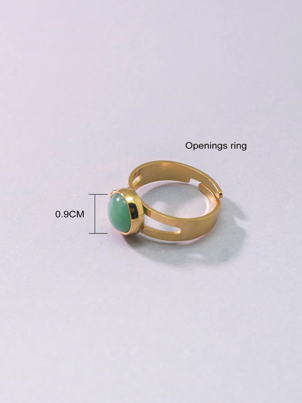 Copper adjustable ring with green natural stone inlay and gold-toned plating on white background