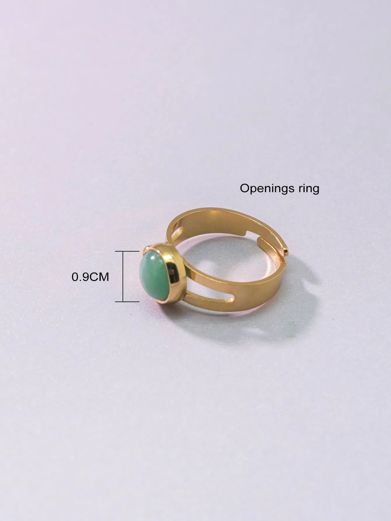 Copper adjustable ring with green natural stone inlay and gold-toned plating on white background
