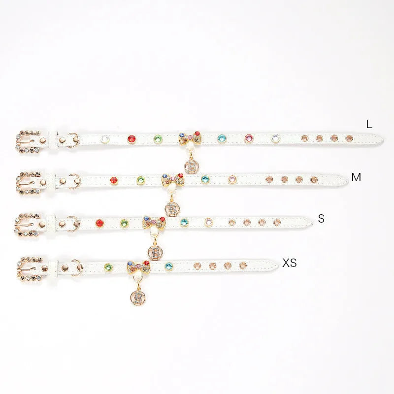 White PU cat collar with diamond alloy bow on a flat surface showing buckle and bow detail