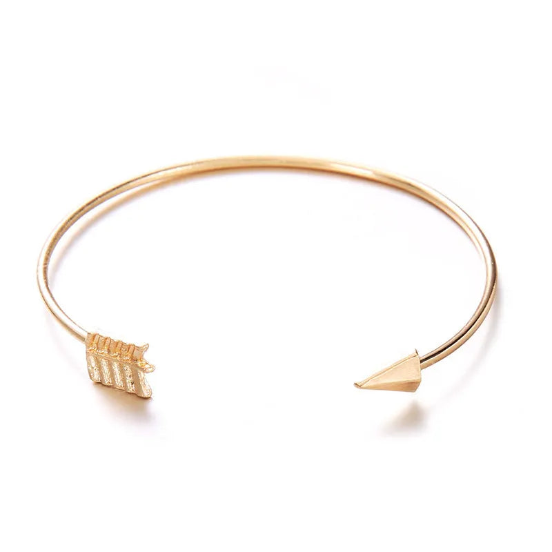 Gold women's vintage cuff bracelet with arrow knotted design on wrist