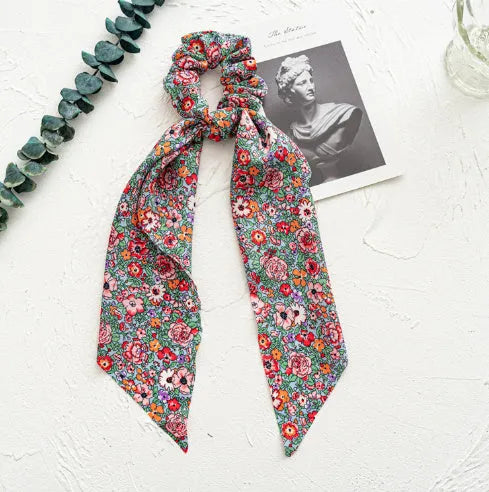 Long dark green floral cloth ribbon hair tie with a large metal ring closure for ponytails.