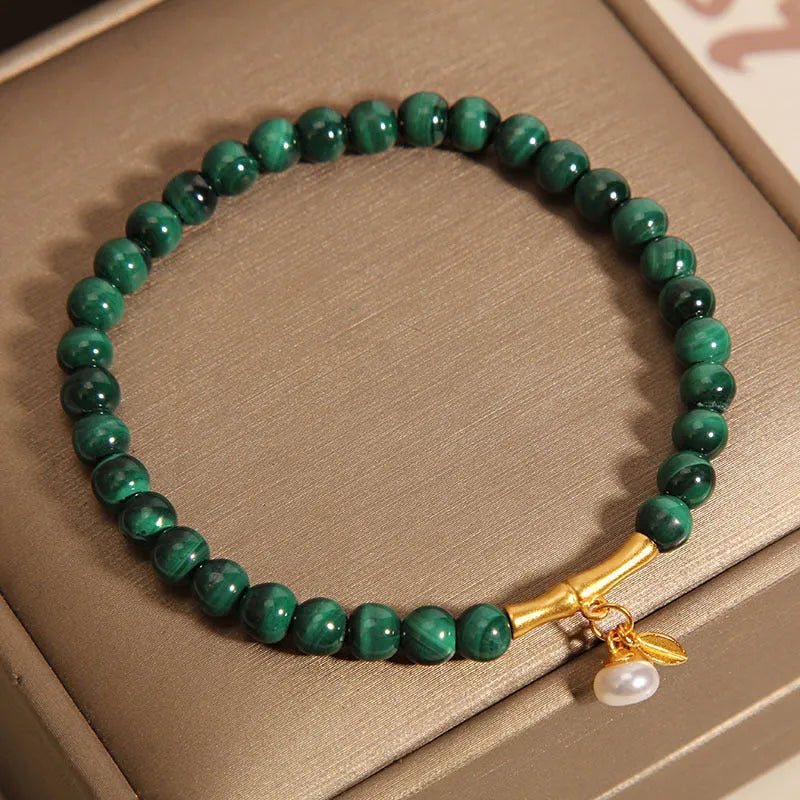 Women's white crystal bracelet with a high-rise lucky bamboo design on a wrist.