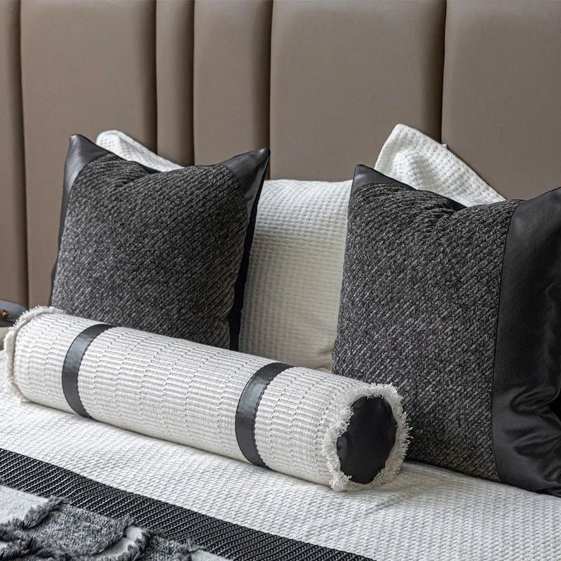Modern minimalist grey and white plaid bed runner blanket with matching pillowcase and round pillow on a double bed.
