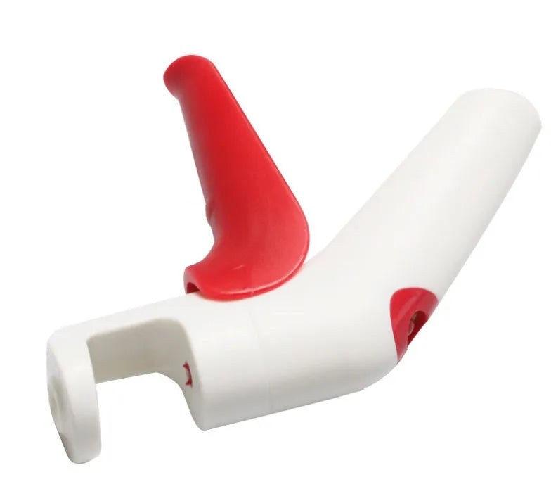 Close-up of a handheld cherry pitter with a plastic handle and stainless steel pitting mechanism