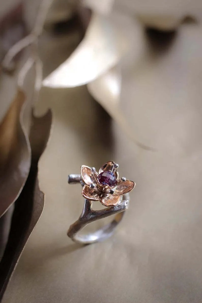 Silver coloured women's alloy ring with geometric shape and two-tone floral design on a white background.