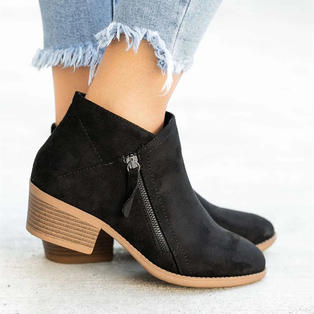 Women's blue suede Dr Martens ankle boots with side zip and chunky heel on a white background.