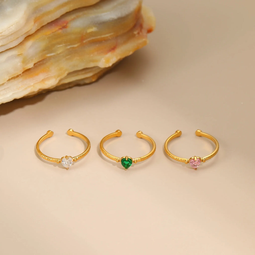 Open-ended stainless steel ring with a geometric heart shape and inlaid green zircon stone.