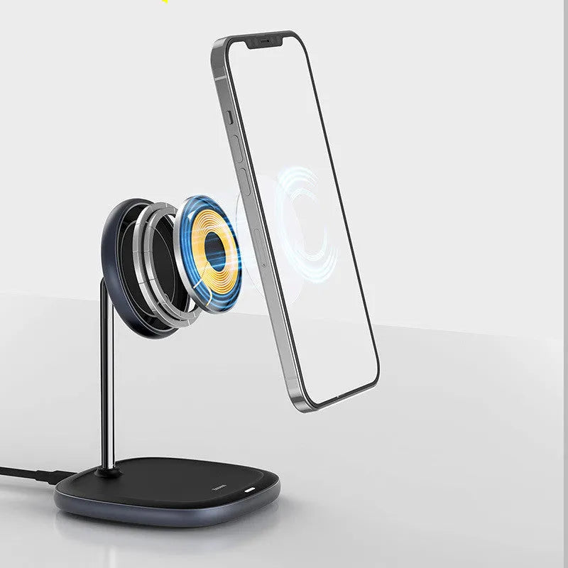Black magnetic wireless charging stand holding an iPhone 12 Pro on a desk.