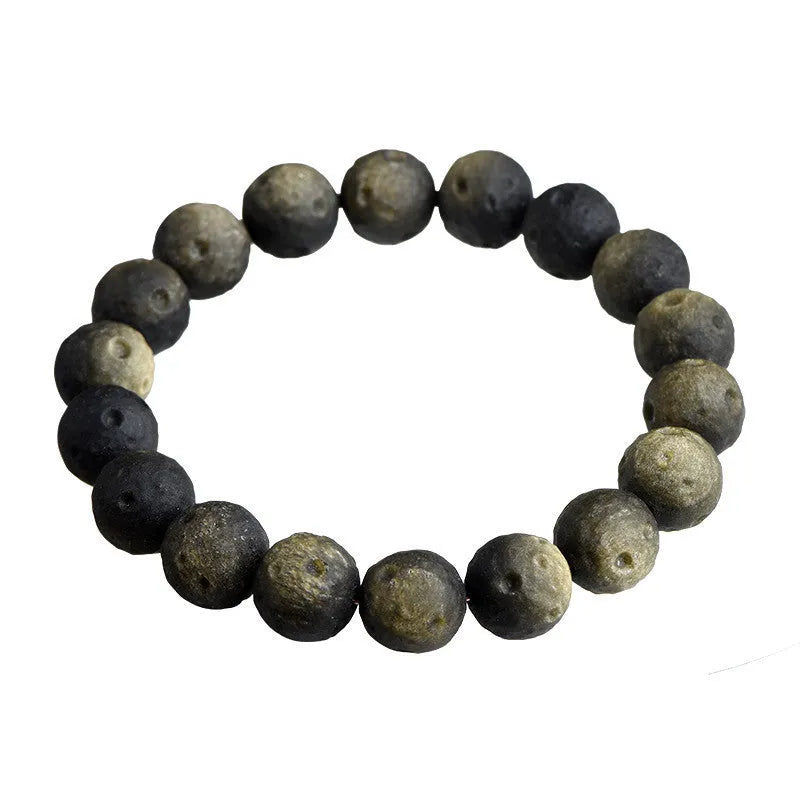 Natural obsidian crater ball bracelet with meteorite-like texture in silver stone or gold finish.