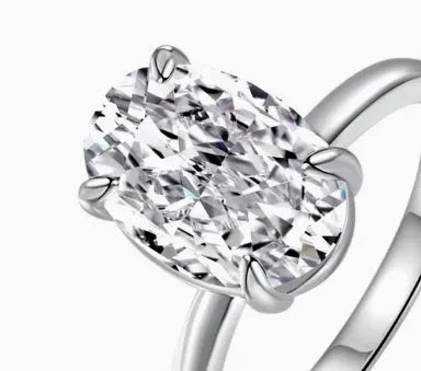 Women's oval four-claw solitaire ring with 6x9mm gemstone in gold or silver finish