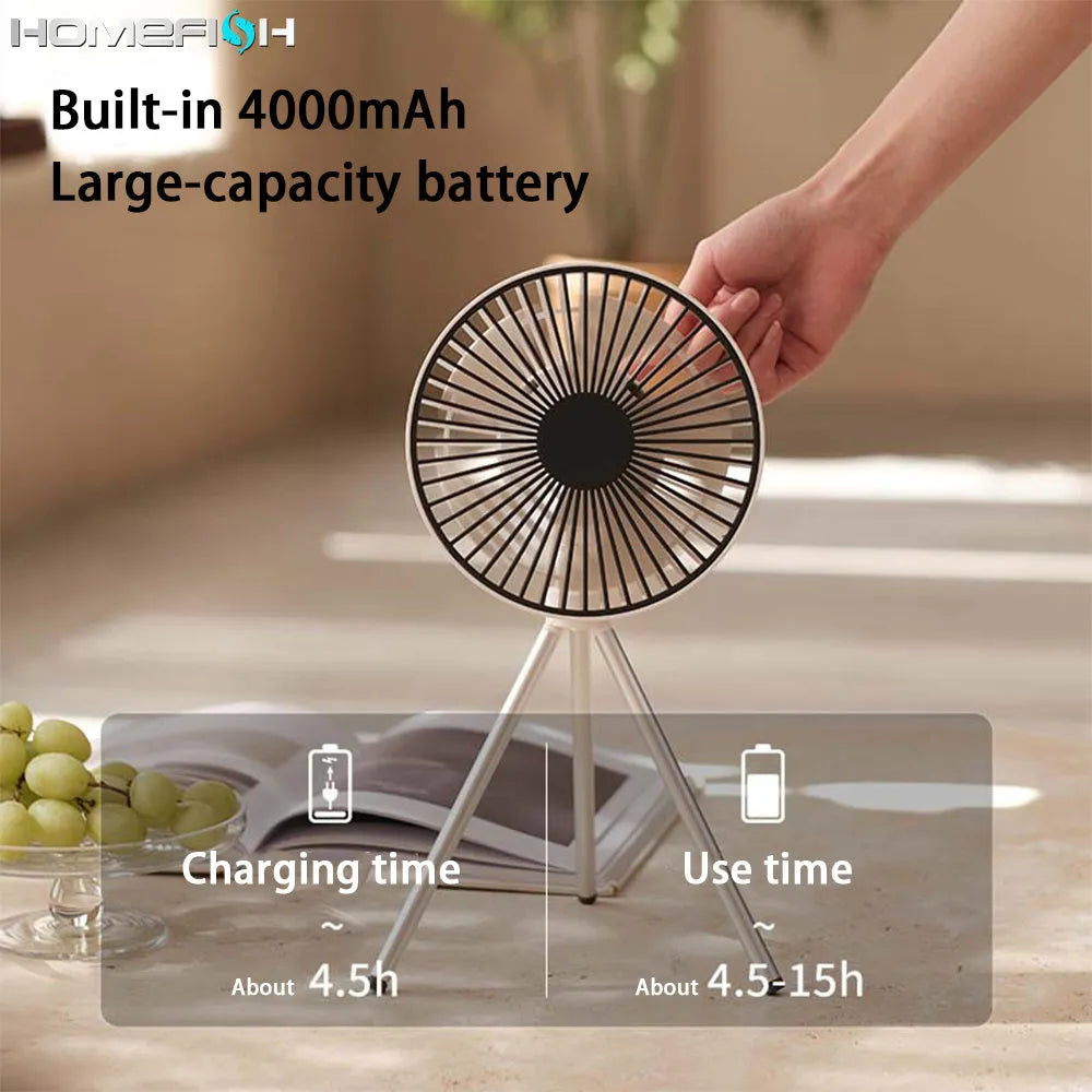 Tripod camping fan in dark grey on a wooden table showing blades and USB port