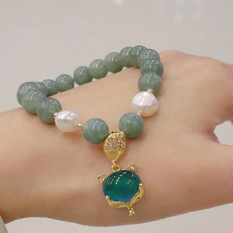 Burma jade warm fox pendant bracelet with temperature-sensitive feature and freshwater pearl accent on white background