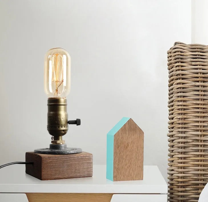 Compact water pipe design table lamp made from wood and iron on a wooden surface.