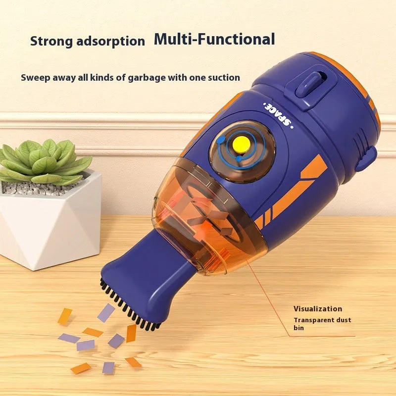 Handheld desktop vacuum cleaner in blue rocket design with USB charging cable on a wooden desk.