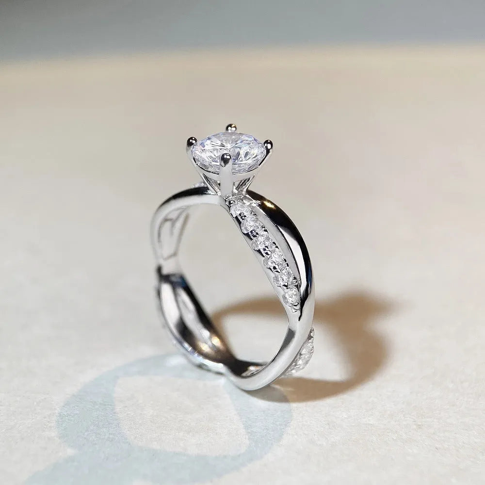 Silver geometric twist band ring with a 1-carat Moissanite stone in a four-claw setting.