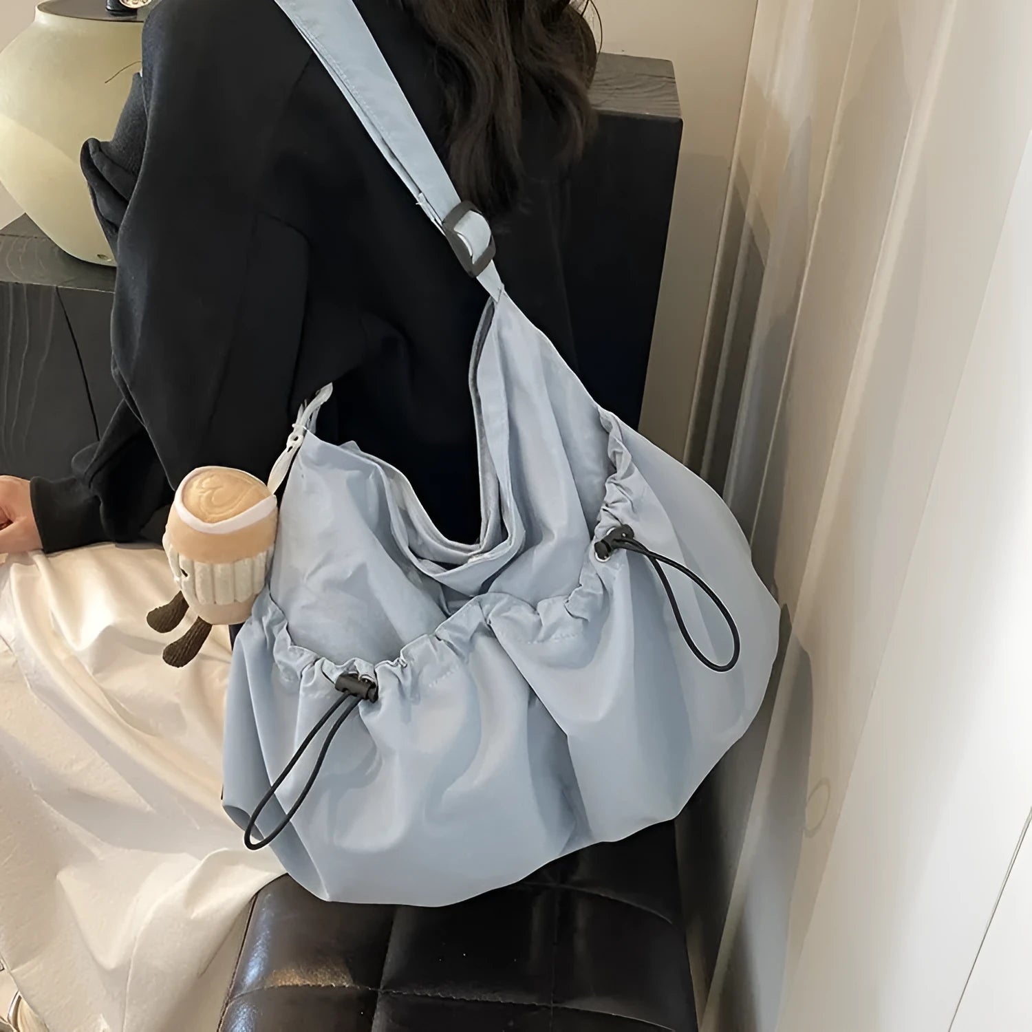 Ultra-light pleated foldable crossbody bag in beige, showing split pocket and crossbody strap.
