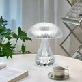 Small white rechargeable touch night lamp with acrylic body and plastic base on a wooden table.