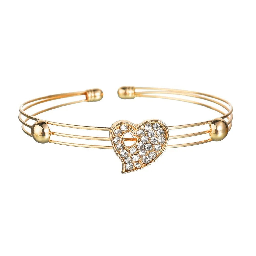 Gold electroplated women's jewellery set with love pendant necklace, earrings, and bracelet on a white background.
