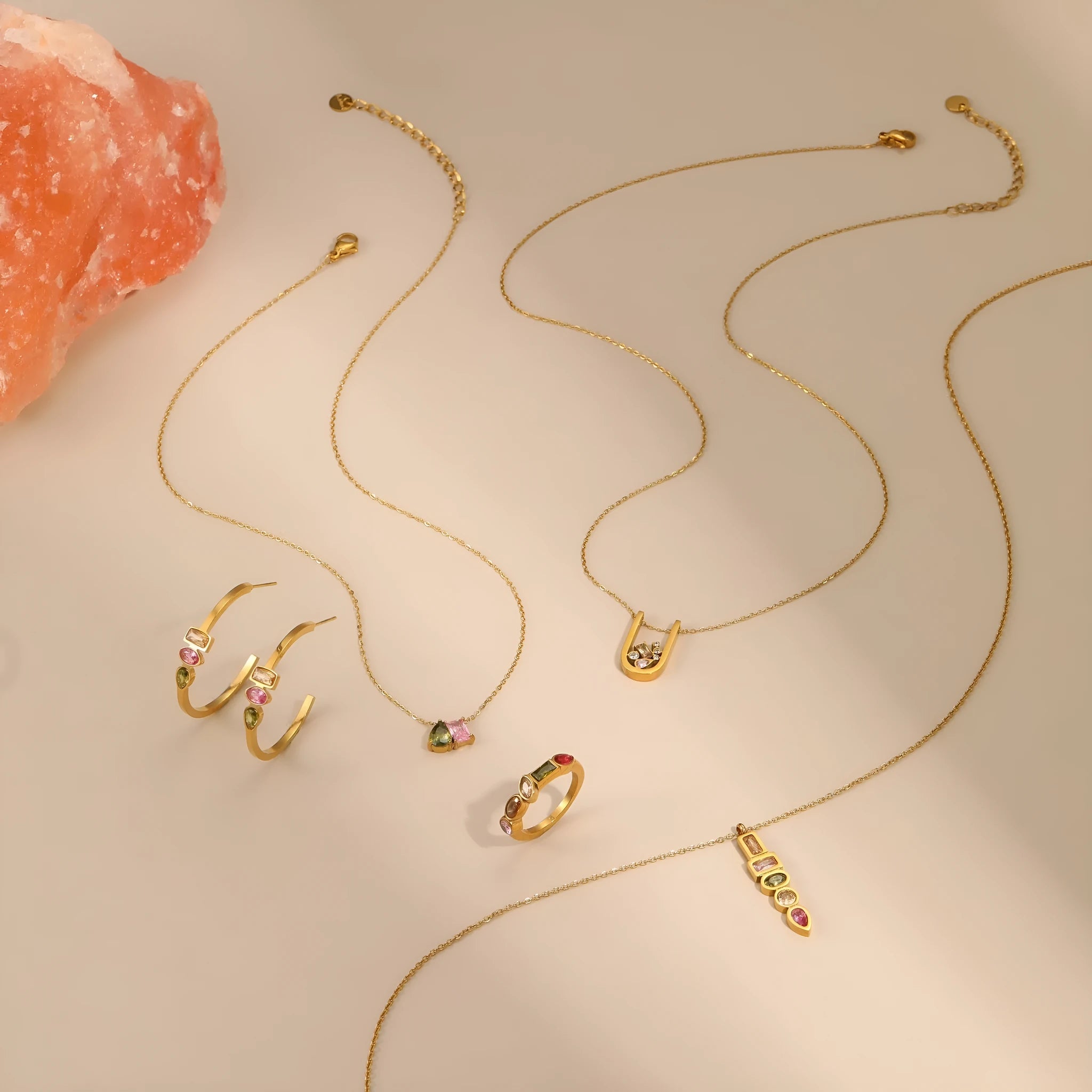 Geometric gold plated jewellery set showing necklace, ring, and earrings with chain design elements