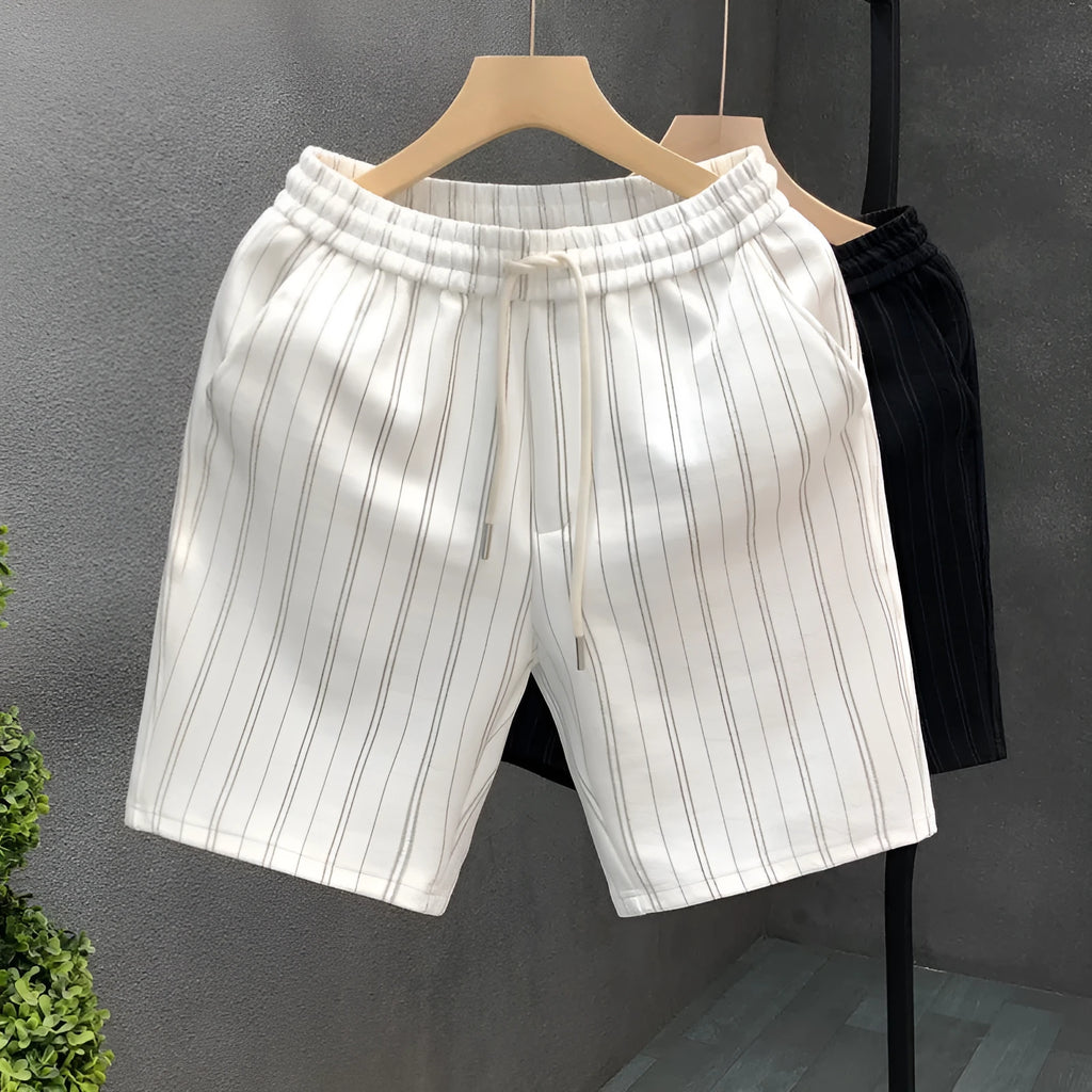 Men's black and white striped fleece-lined casual shorts with an elastic waistband on a grey background.