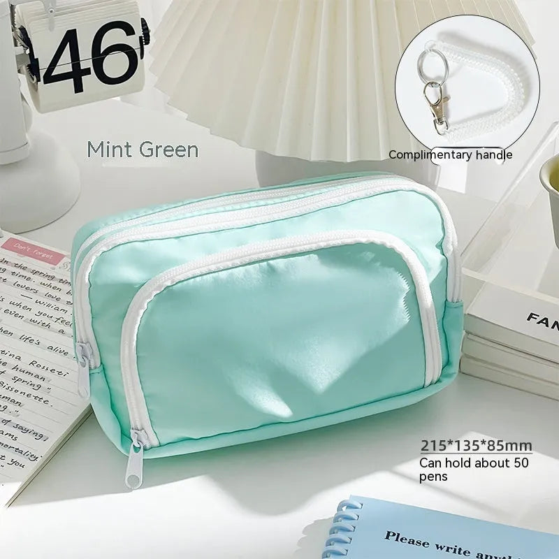 Double-layer pencil case in blue showing internal compartments and a top carry handle