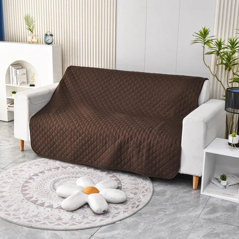 Reversible grey and burgundy waterproof dog blanket laid flat on a sofa.