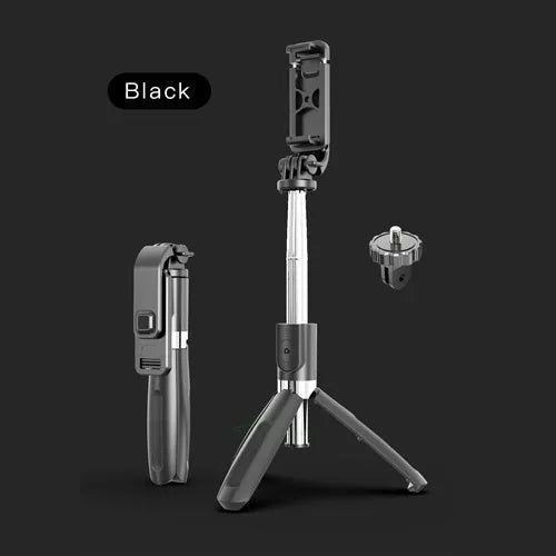 Extended black Bluetooth selfie stick with phone attached and separate wireless remote on a table