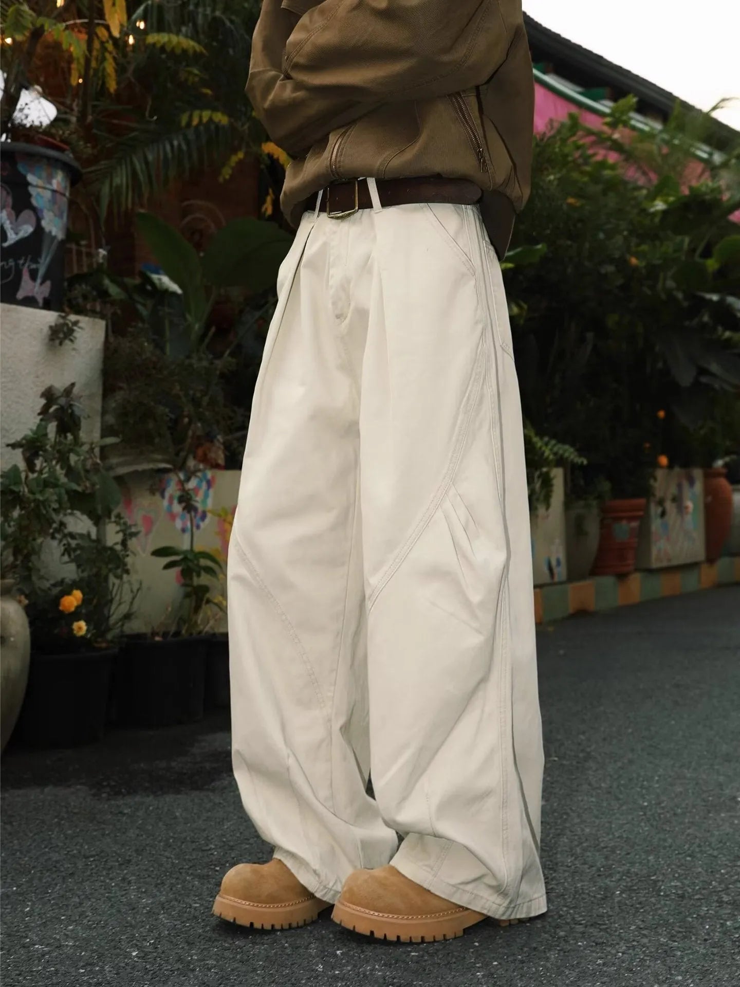 Men's pleated straight-leg trousers in apricot colour on a hanger