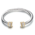 Two-tone vintage gold stainless steel bangle bracelet with black and golden finish on white background
