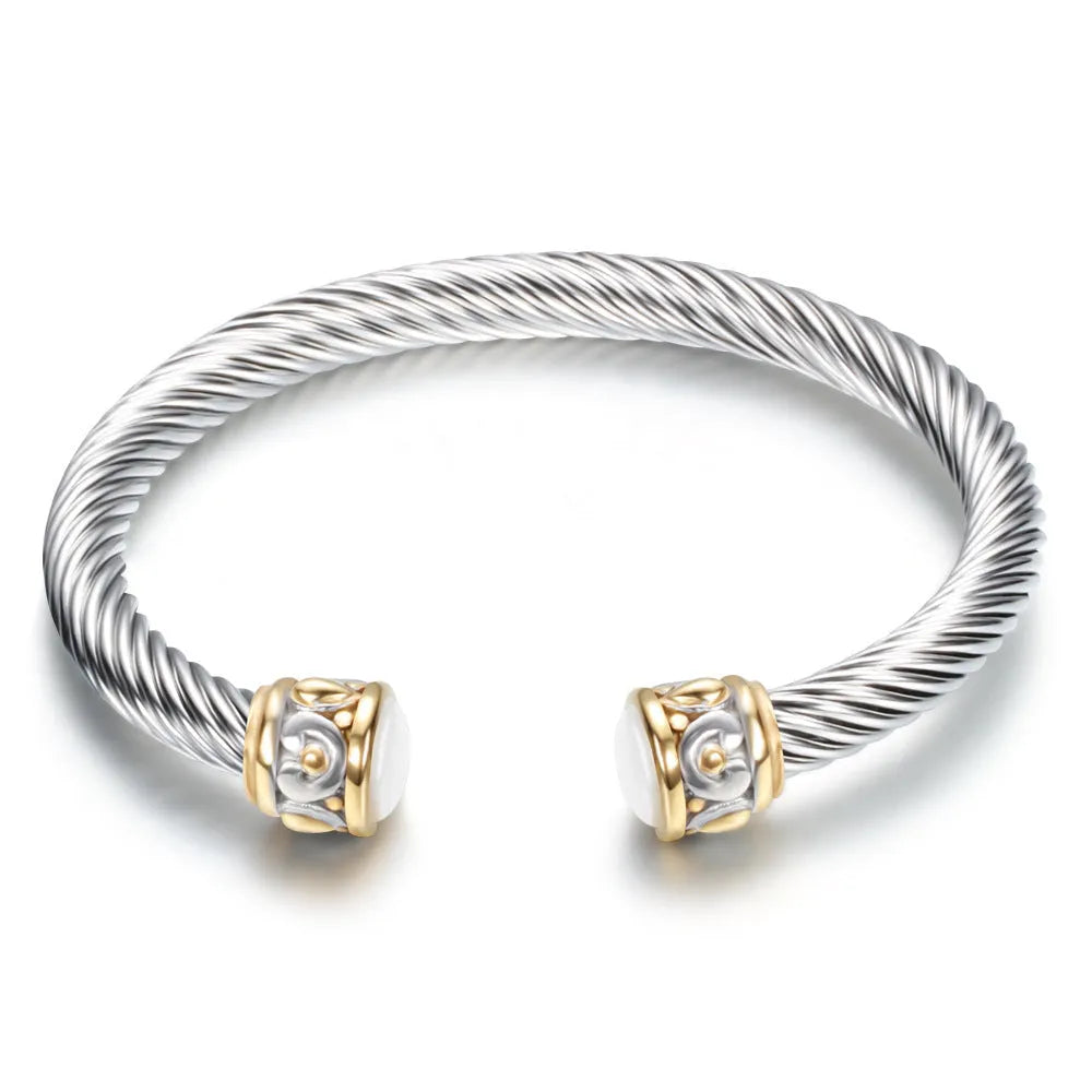 Two-tone vintage gold stainless steel bangle bracelet with black and golden finish on white background