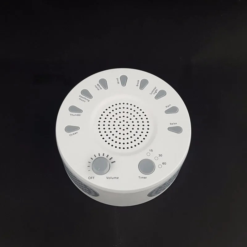 White portable white noise sleep sound machine with control knob on a bedside table.