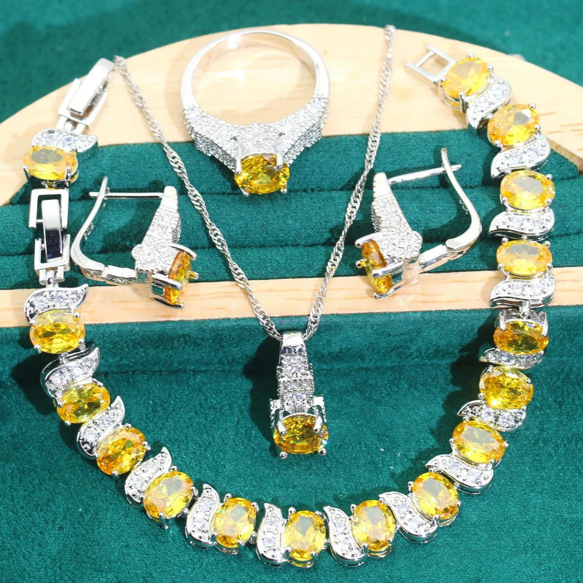 Four-piece bridal jewellery set showing zirconium alloy necklace, earrings, ring, and bracelet in water wave chain design.