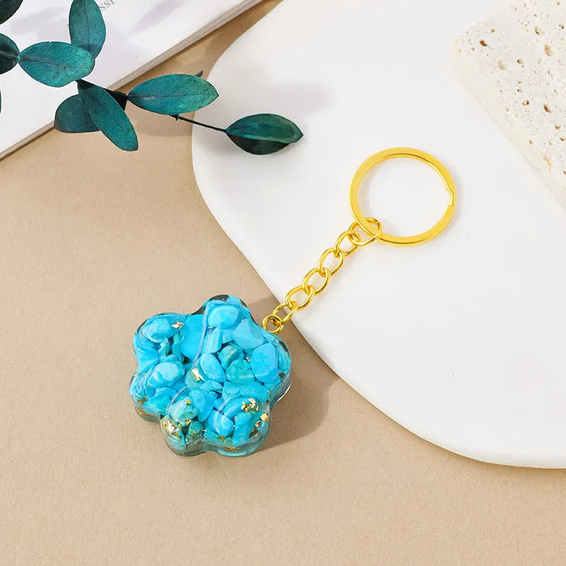 Small natural crystal cat's paw keychain pendant on a metal ring.
