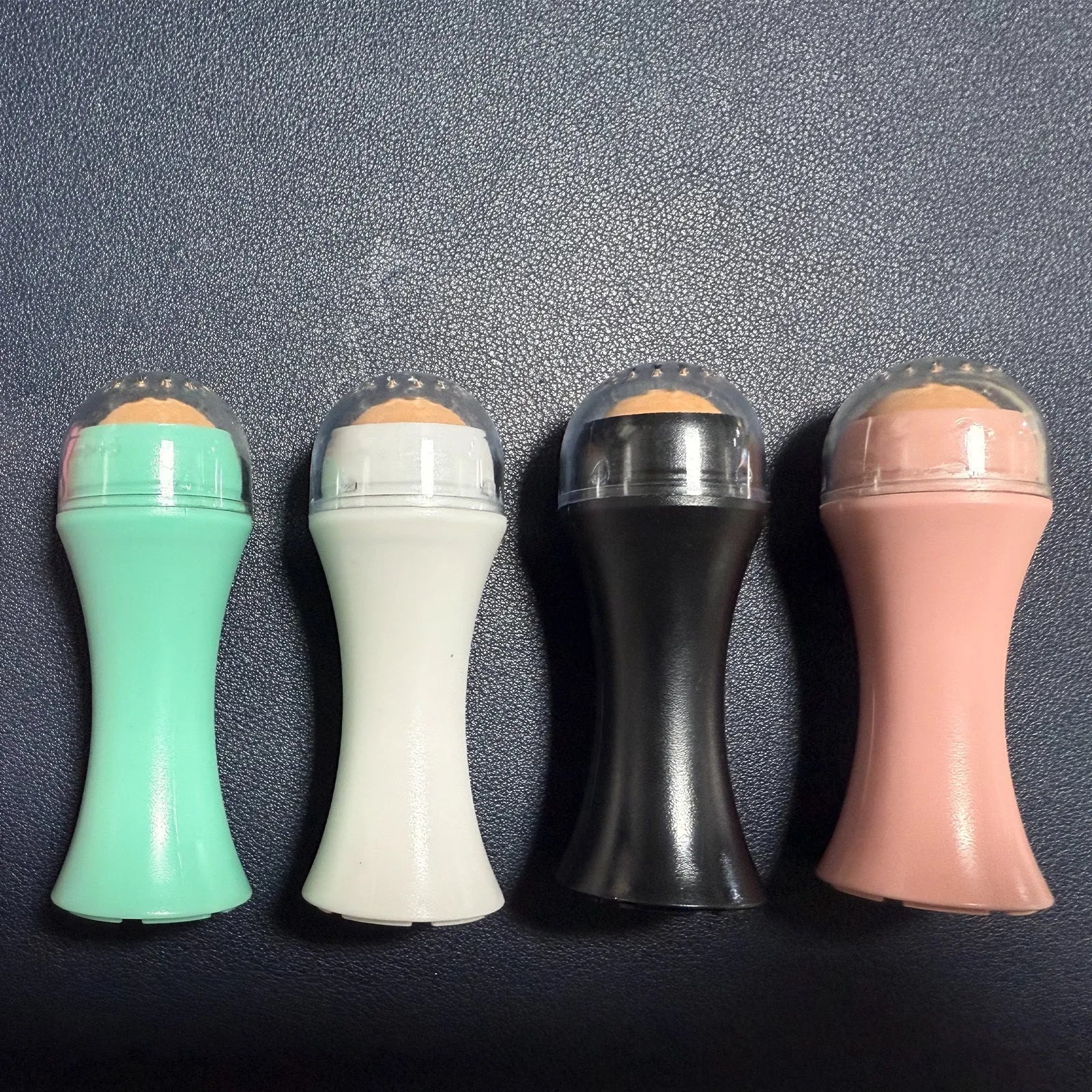 Volcanic stone oil absorbing roller in black, green, pink, or white for facial skincare