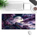 Large black gaming mouse pad with geometric pattern, shown on desk with keyboard and mouse