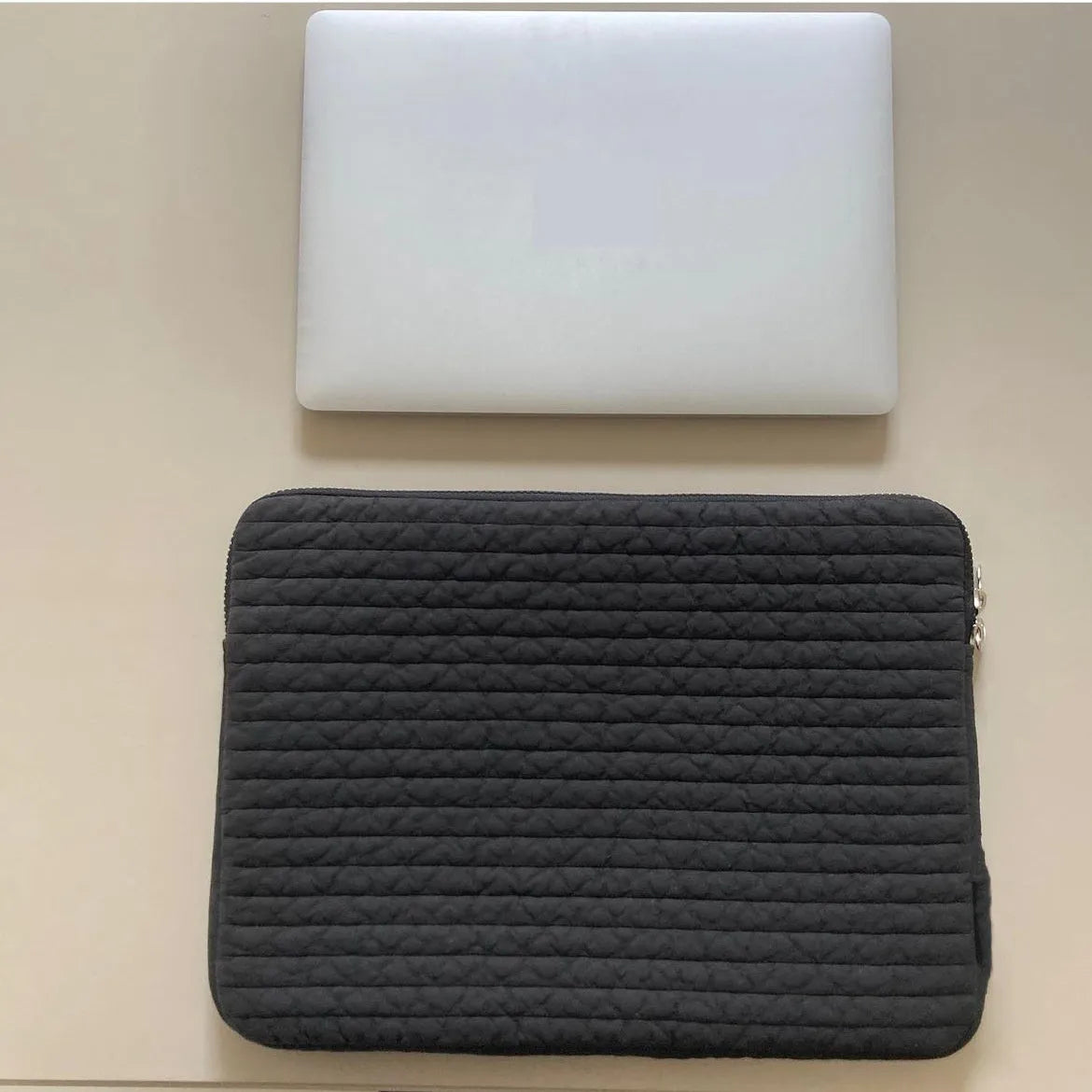 Black and white cotton cloth anti-seismic laptop bag in clutch style for 11-inch to 15.6-inch devices.