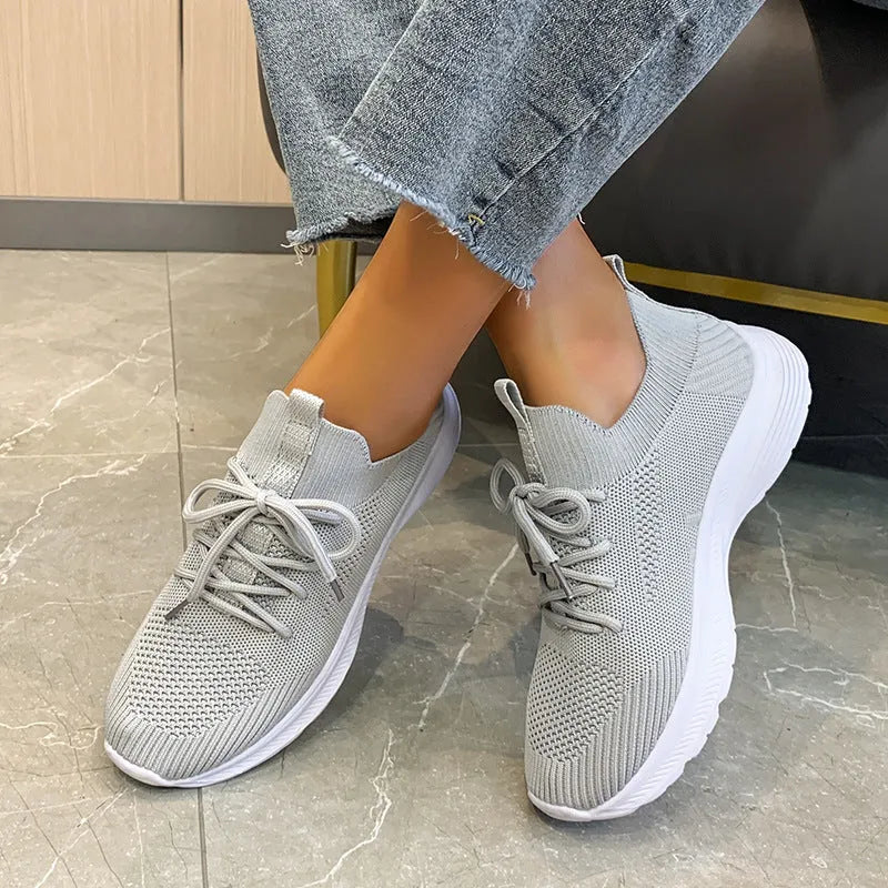 Women's low-top running shoes in Creamy White with mesh detailing and a flat rubber sole.