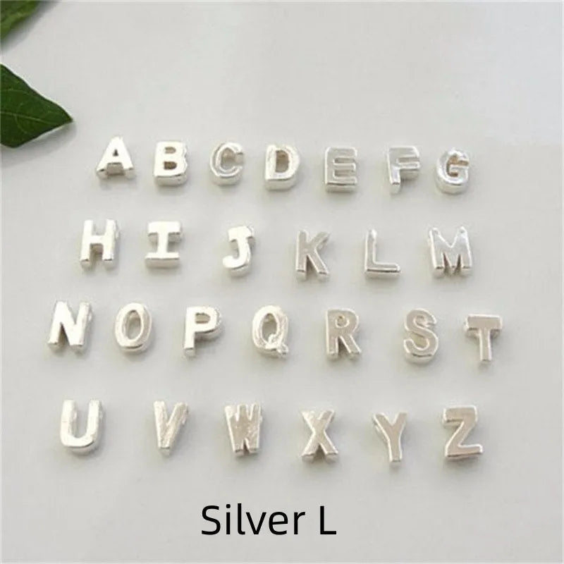 Golden peach heart shaped alloy necklace pendant with a letter design on a white background.