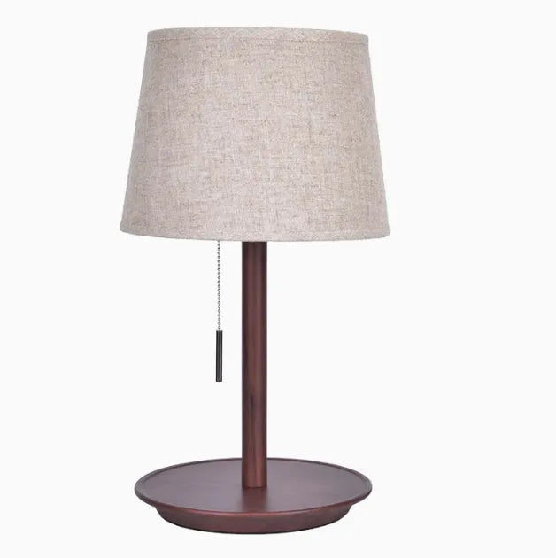 Walnut coloured solid wood bedside table lamp with a white cloth lampshade.