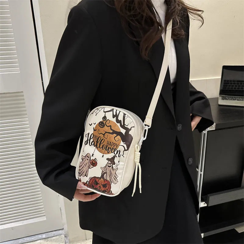 Black mini crossbody phone bag with Halloween graffiti print showing pumpkins, ghosts and bats