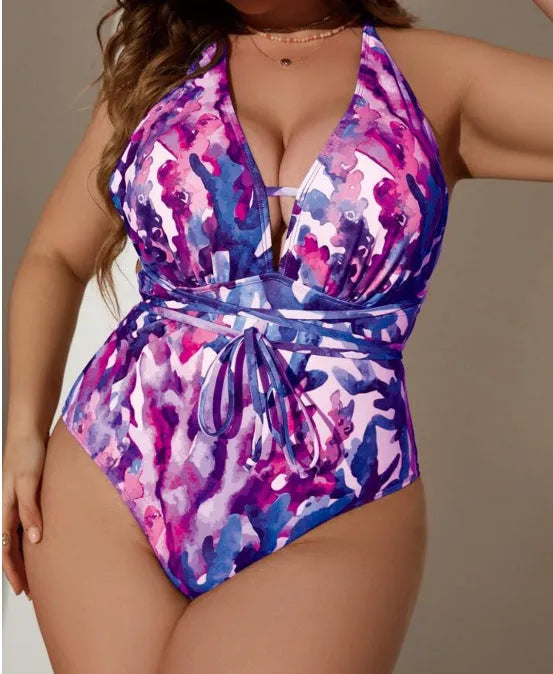 Purple and blue solid colour women's halter neck one-piece swimsuit on a hanger.