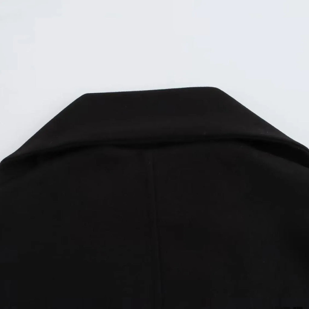 Women's long black polyester winter coat with a fluffy artificial fur collar, shown in a street fashion style.