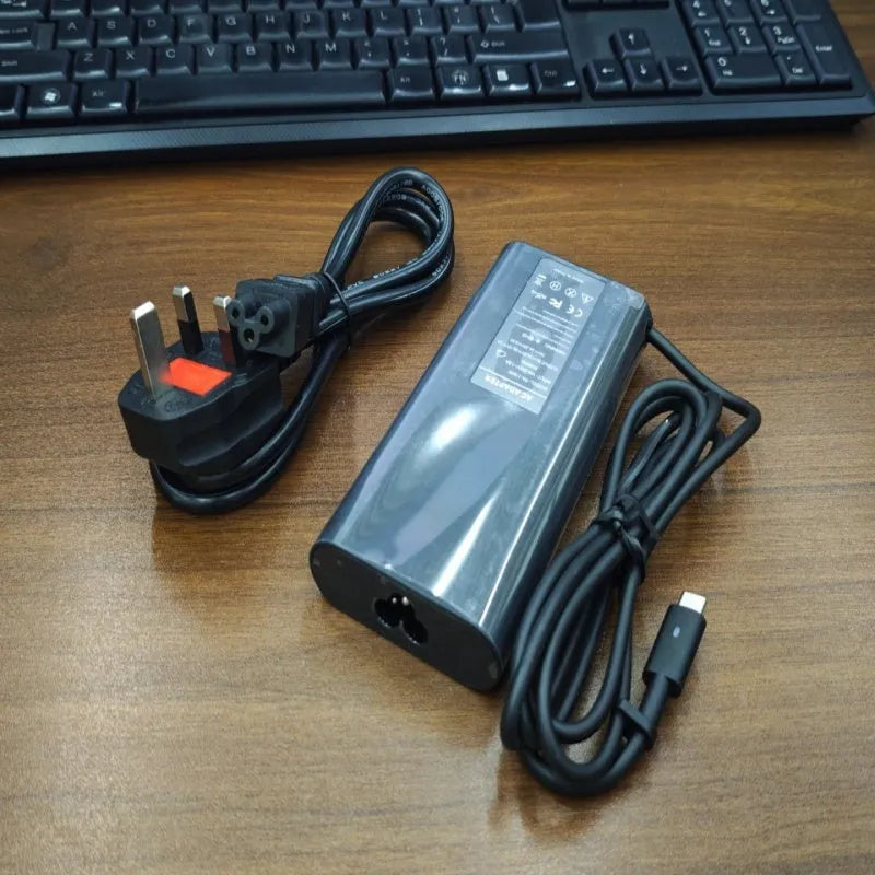Black 65W USB-C laptop power adapter with set of international plug cords.