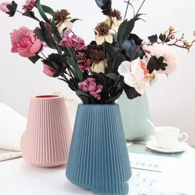 White melamine plastic decorative flower vase measuring 16cm by 20cm on a desktop