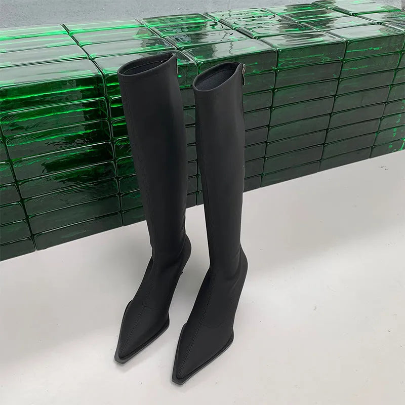 Black women's knee-high pointed toe boots with a stiletto heel and back zip fastening.