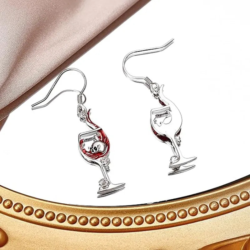 Close-up of a pair of geometric zinc alloy earrings with a skull and wine glass design and electroplated finish.