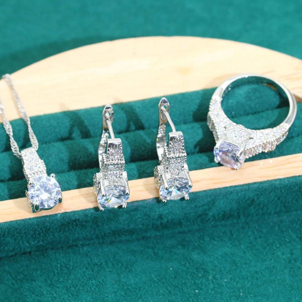 Four-piece bridal jewellery set showing zirconium alloy necklace, earrings, ring, and bracelet in water wave chain design.
